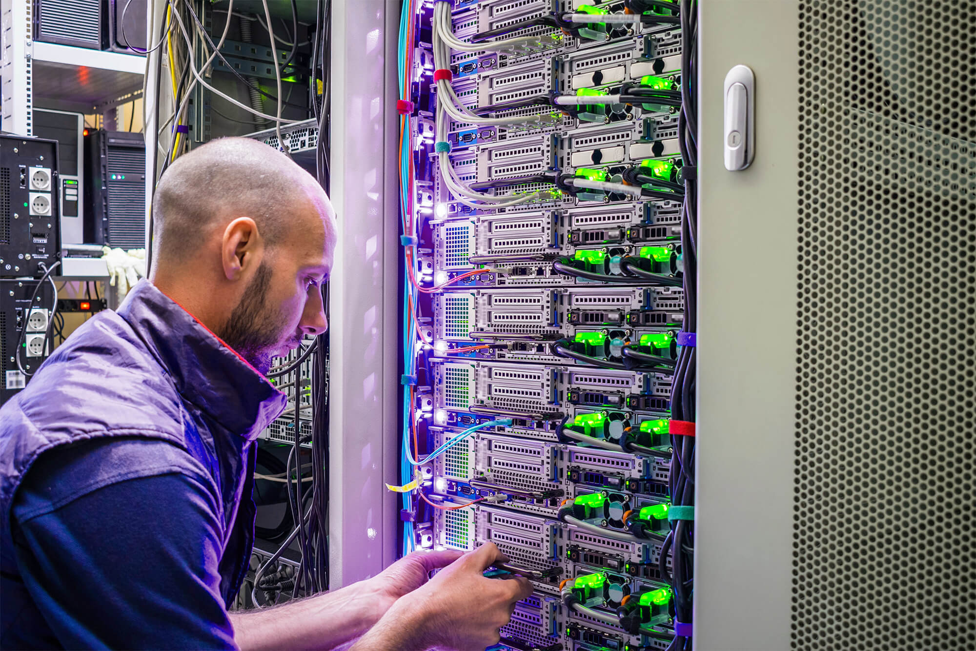 engineer working inside industrial server rack supporting operational technology infrastructure and real-time system monitoring