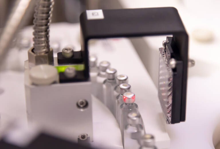 Pharmaceutical vials on automated conveyor undergoing quality inspection