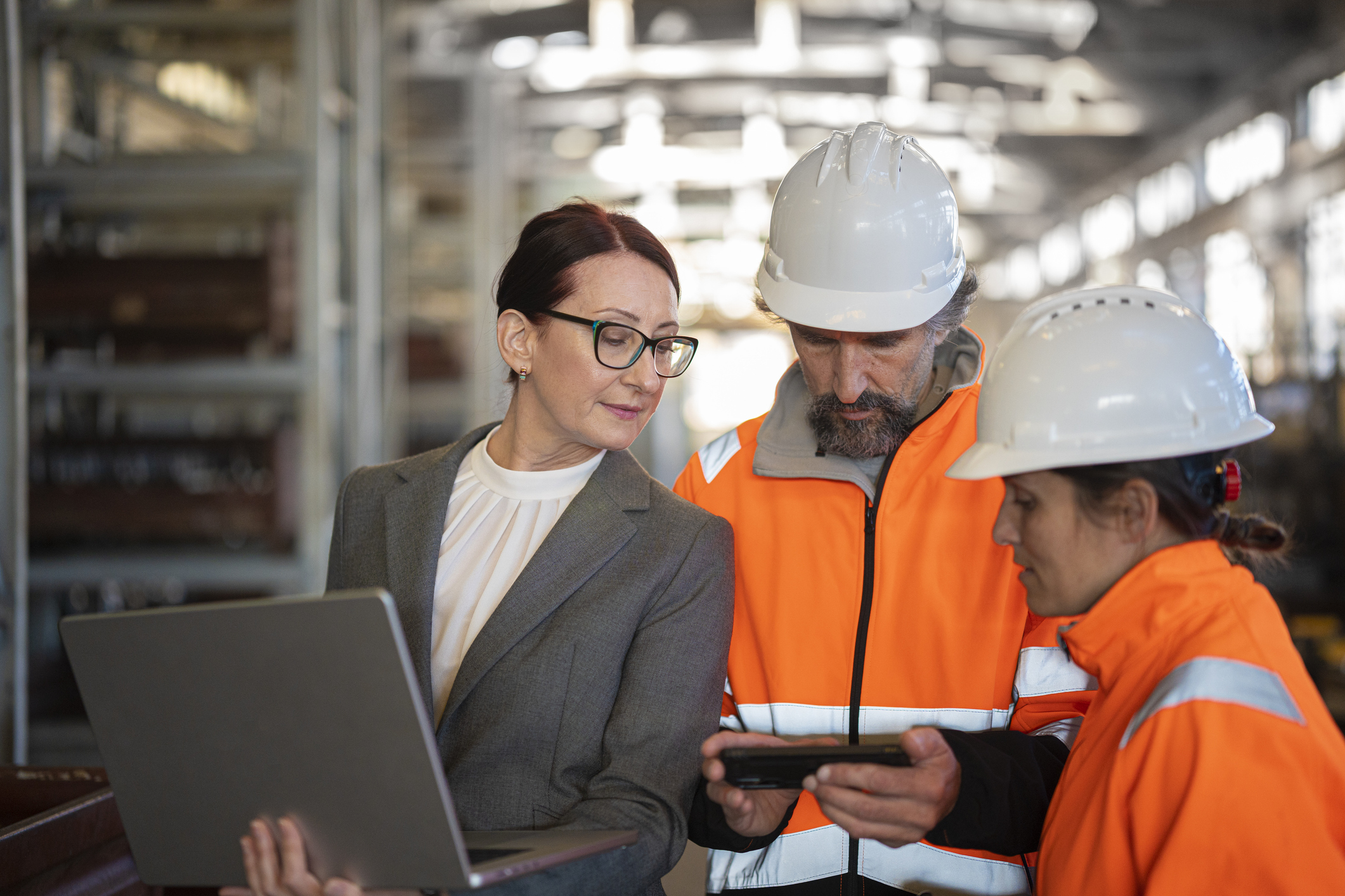 manufacturing leaders and plant-floor personnel review production data together to align AI governance, operational decisions, and change management before deployment
