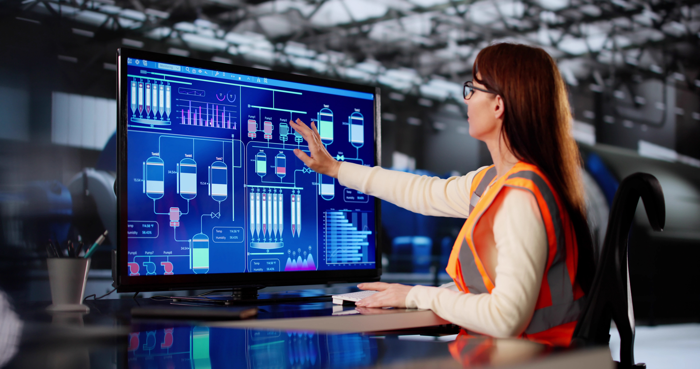 operator reviewing an industrial control system dashboard in a manufacturing facility, illustrating the connection between operational technology, enterprise systems, and AI-ready data flows