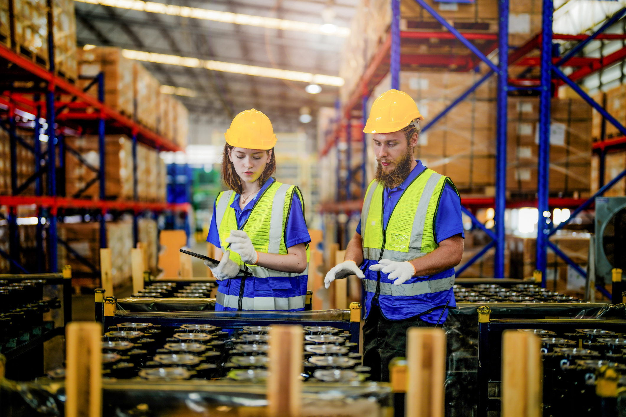 factory workers inspecting machine parts in a warehouse, representing labor costs, quality control, and operational impact during unplanned downtime